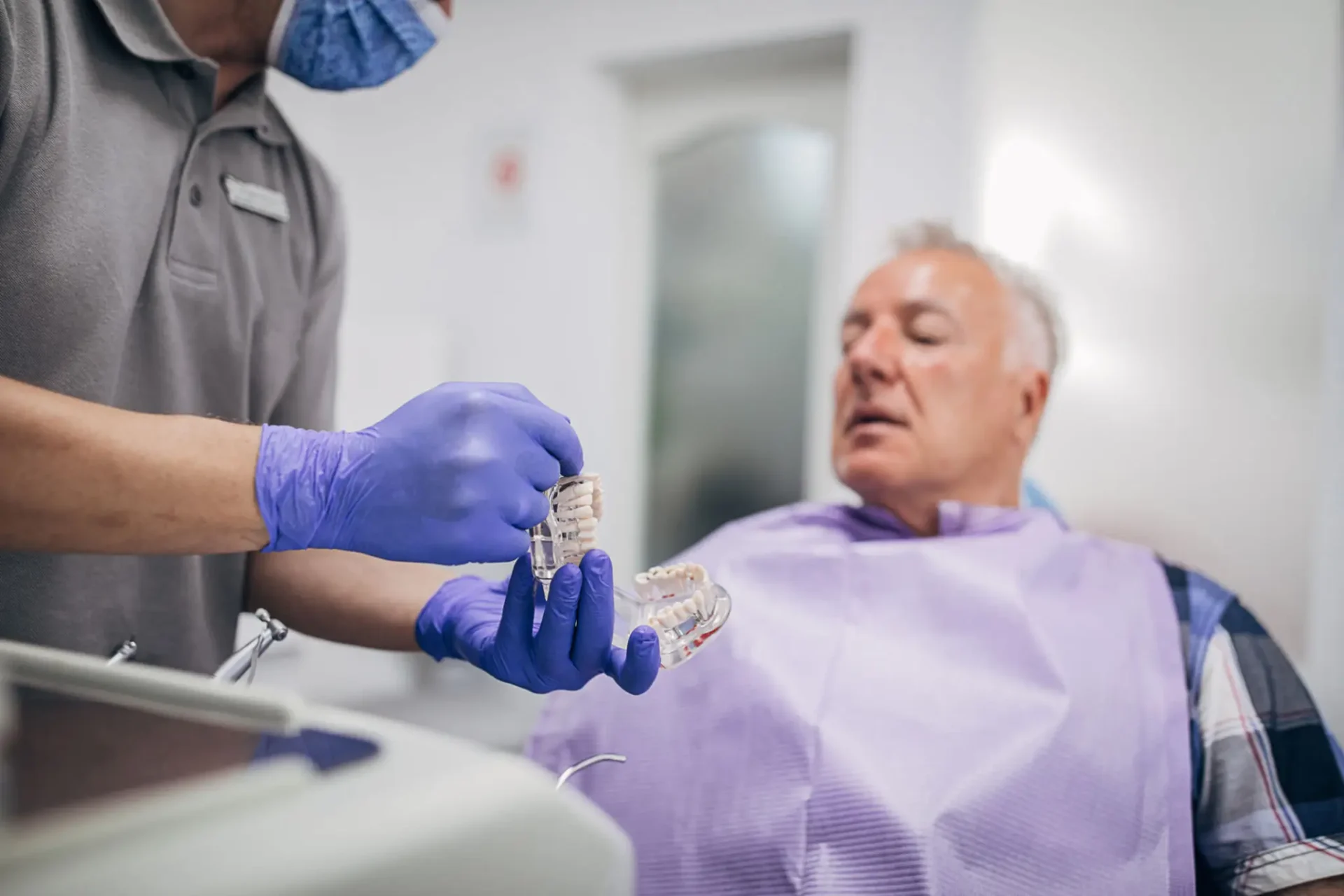 A healthcare worker prepares to take blood from a patient.