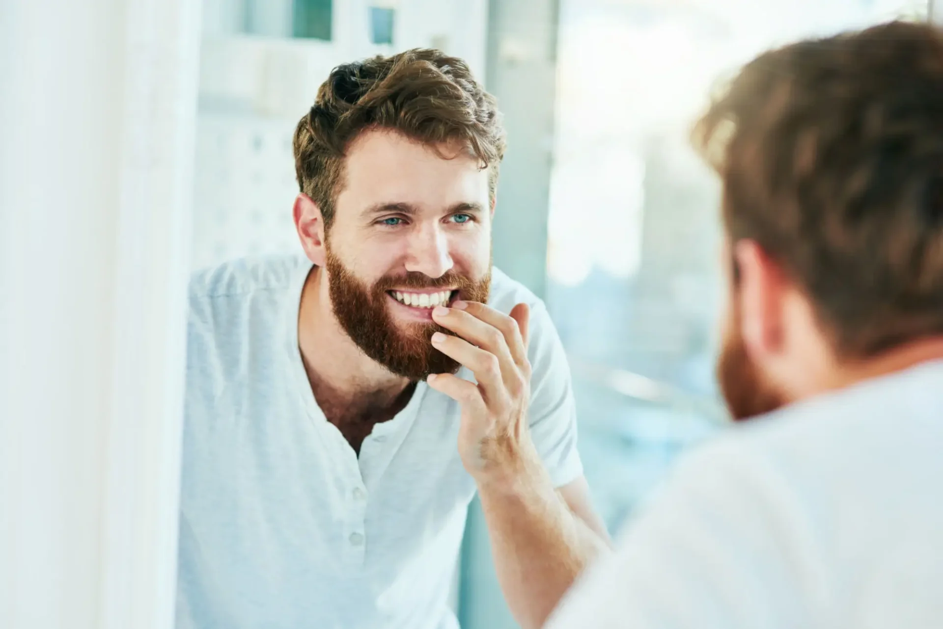 Man smiling while looking in the mirror.