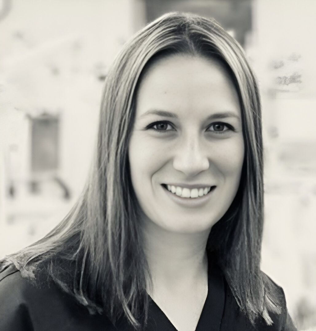 Black and white portrait of a smiling woman with long hair.